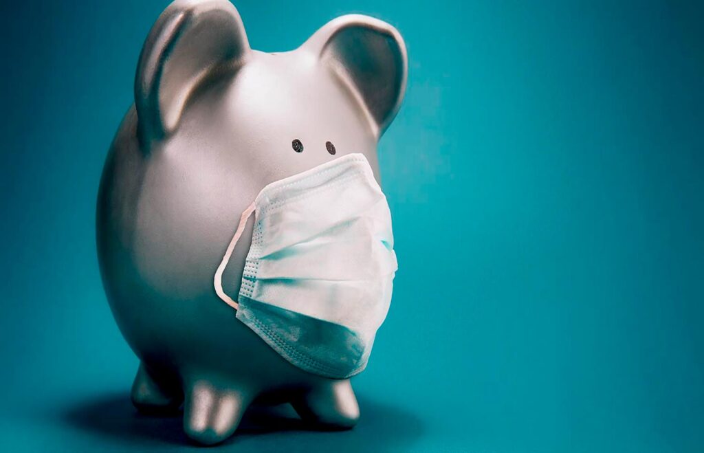 Close up of piggy bank, wearing protective face mask, isolated o